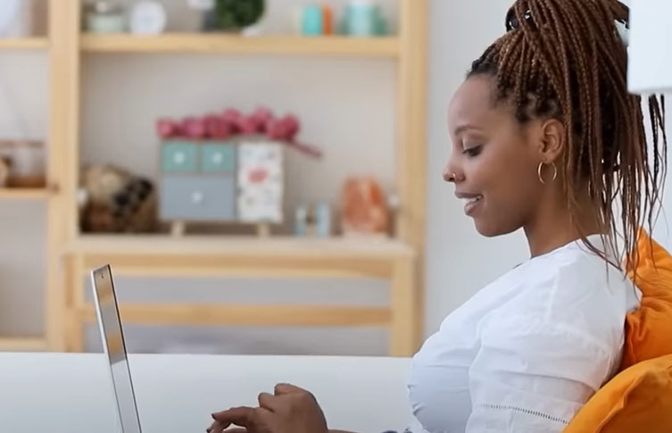 happy woman on her laptop after taking inpatient rehab